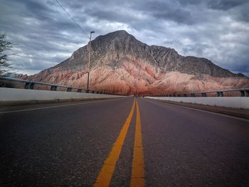 Surface level of empty road against mountain range