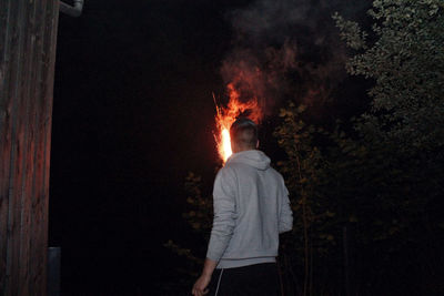 Rear view of woman standing at night