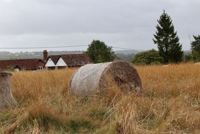 Hay bales on field against sky