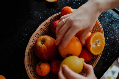 Midsection of person holding fruits in basket