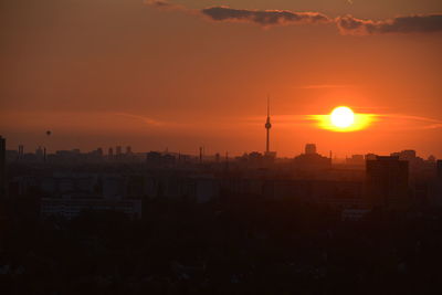 Silhouette buildings against sky during sunset