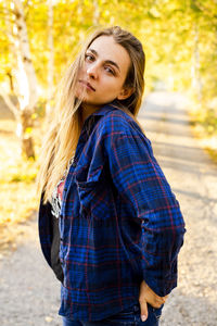 Portrait of woman standing against tree