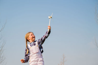 Low angle view of woman standing against sky