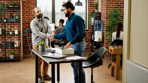 Young man using laptop while sitting on table