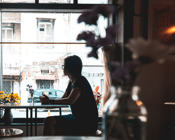 Side view of a woman sitting at restaurant table