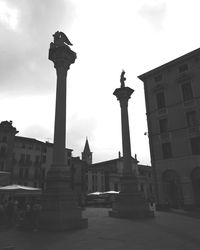 Low angle view of buildings against cloudy sky