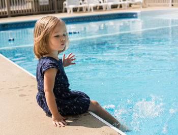 Portrait of cute girl sitting in swimming pool
