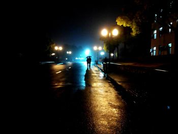 Woman walking on road at night