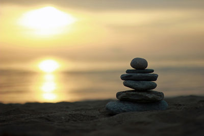 Stack of stones on beach during sunset