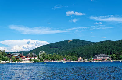 Scenic view of lake titisee and mountains against blue sky