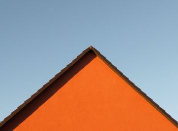 Low angle view of orange building against clear sky