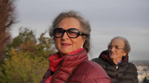 Senior couple wearing warm clothing while standing against sky