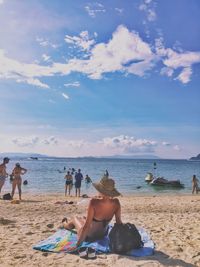 People at beach against sky