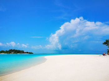 Scenic view of beach against blue sky