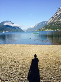 Shadow of man on beach against clear sky