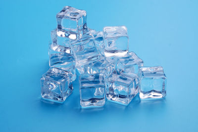 Close-up of ice crystals on table against blue background