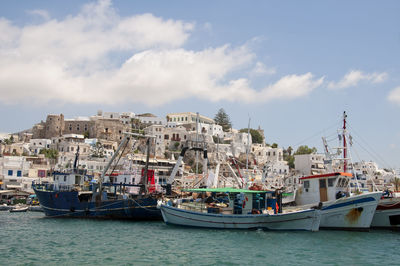 Boats moored at harbor in city