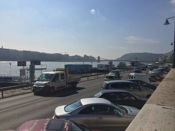 Cars on road in city against sky