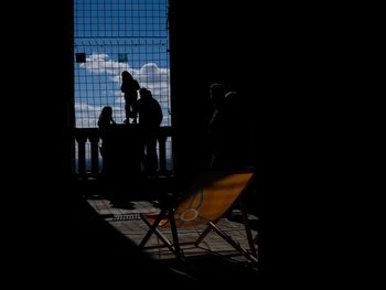 Silhouette man and chair in dark room