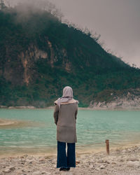 Rear view of woman standing on beach