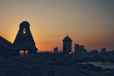 Buildings against sky during sunset in city