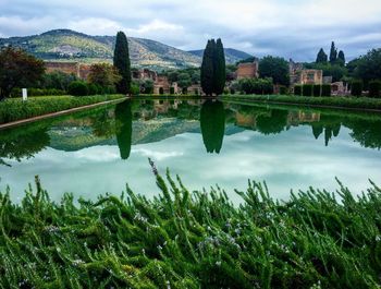 Scenic view of lake in front of town against sky