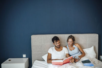 Young couple sitting on smart phone at home
