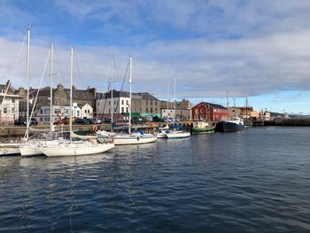 Sailboats moored in harbor