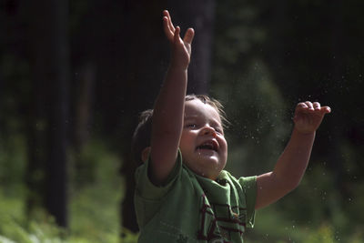 Boy with arms raised in the background