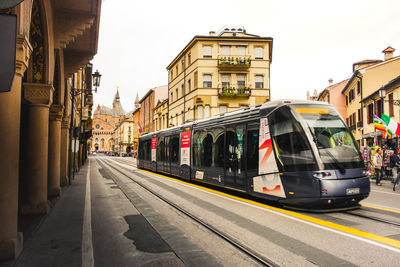 Train on railroad tracks in city against sky