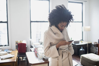 Woman using smart phone in office