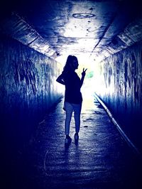 Full length of woman standing on footpath in tunnel
