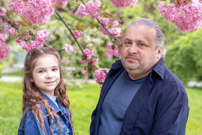 Father and daughter smiling looking at the camera against the backdrop of flowering saruka 