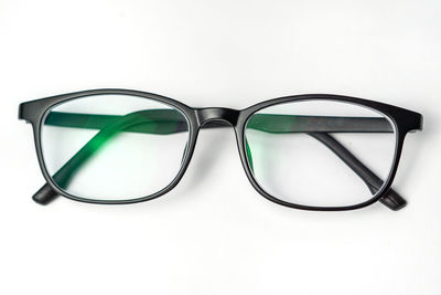 Close-up of eyeglasses on table against white background