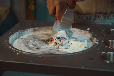 Midsection of person preparing food in container