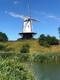 Traditional windmill on landscape against sky