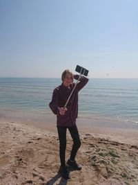 Full length portrait of man standing on beach