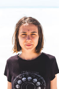 Portrait of beautiful young woman standing against white background