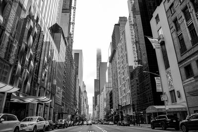 Panoramic view of city street amidst buildings against sky