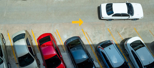 Top view of car parked at concrete car parking lot with yellow line of traffic sign on the street. 