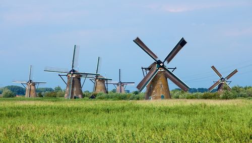 Traditional windmills on field against sky