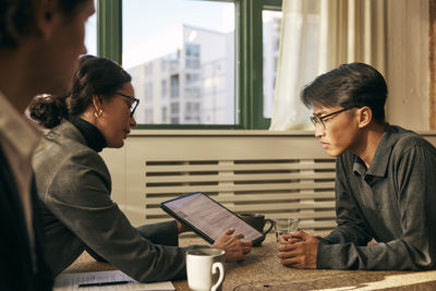 Side view of man using laptop at office