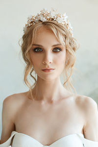 Portrait of bride standing by wall