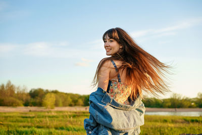 Portrait of a beautiful young woman with fluttering hair in nature