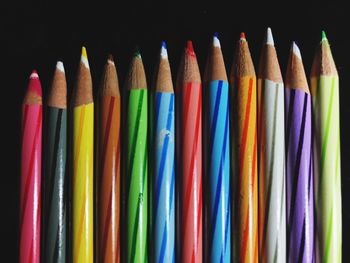 Close-up of colorful pencils against colored background