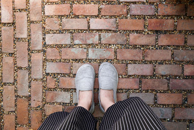 Low section of woman standing on footpath