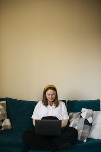 Woman on sofa using laptop