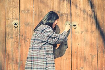 Woman standing on wooden door