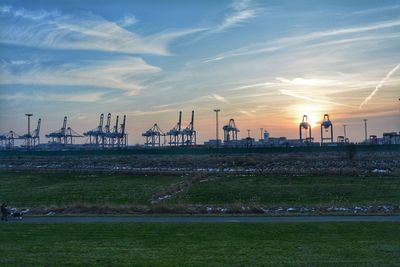 Panoramic view of factory against sky during sunset