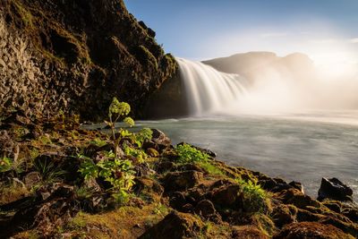 Scenic view of waterfall against sky